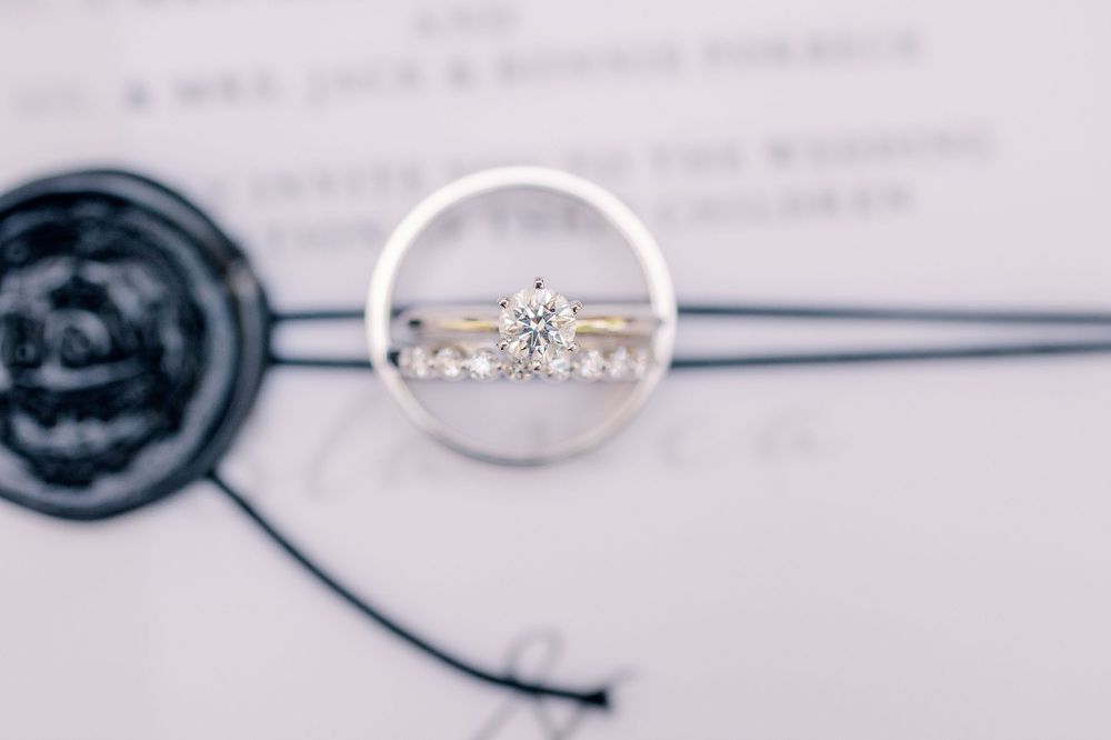 Close-up view of a diamond engagement ring captured through a circular lens.