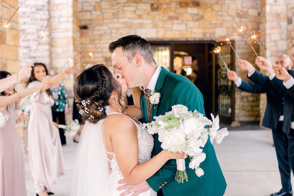 Joyful wedding celebration with elegant white floral bouquet against brick architecture.