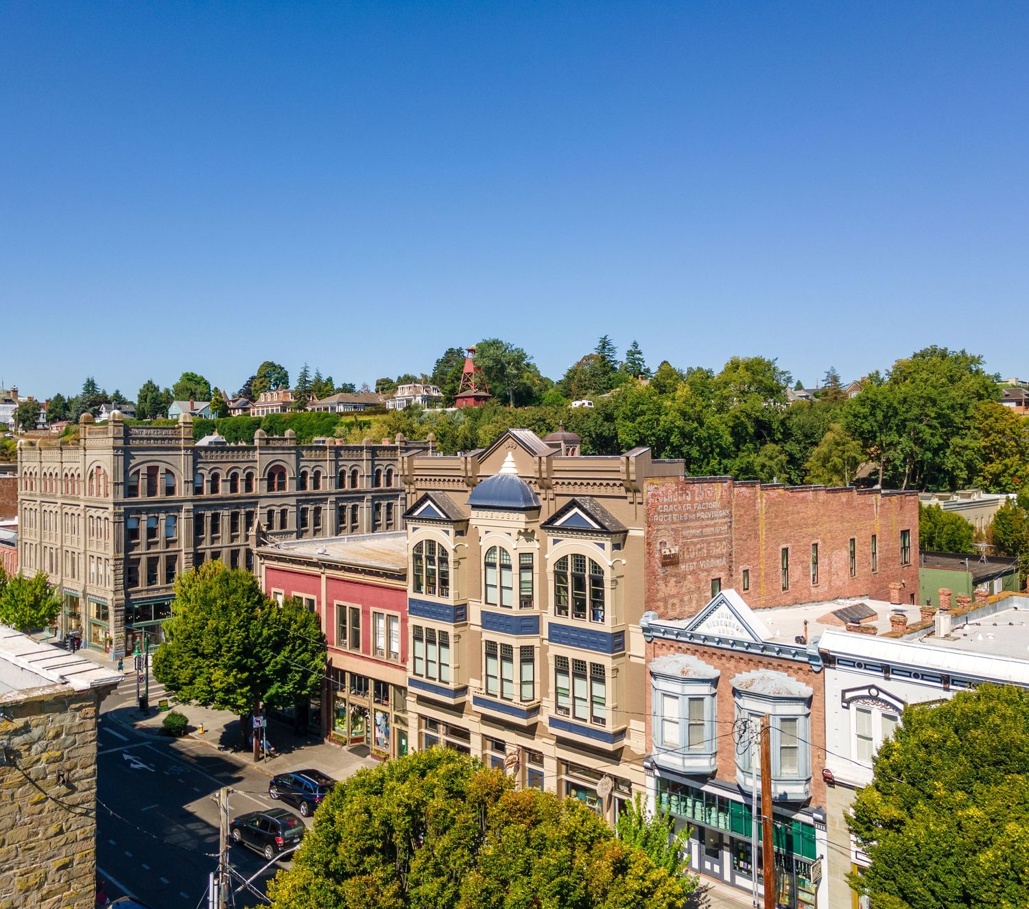 Historic downtown row of Victorian-style brick buildings with ornate architecture on a sunny day.