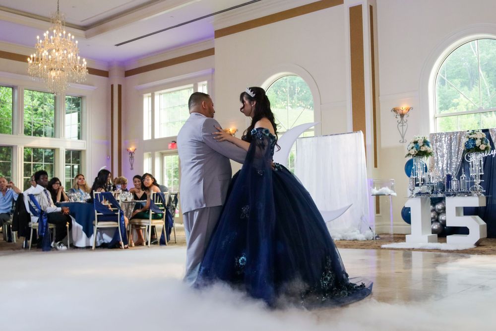 A couple shares a dance on a ballroom floor during a formal celebration.