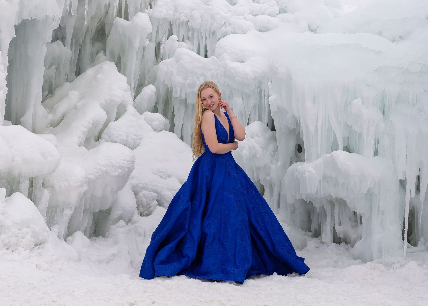 senior in blue prom dress posed in front of ice castle midway utah