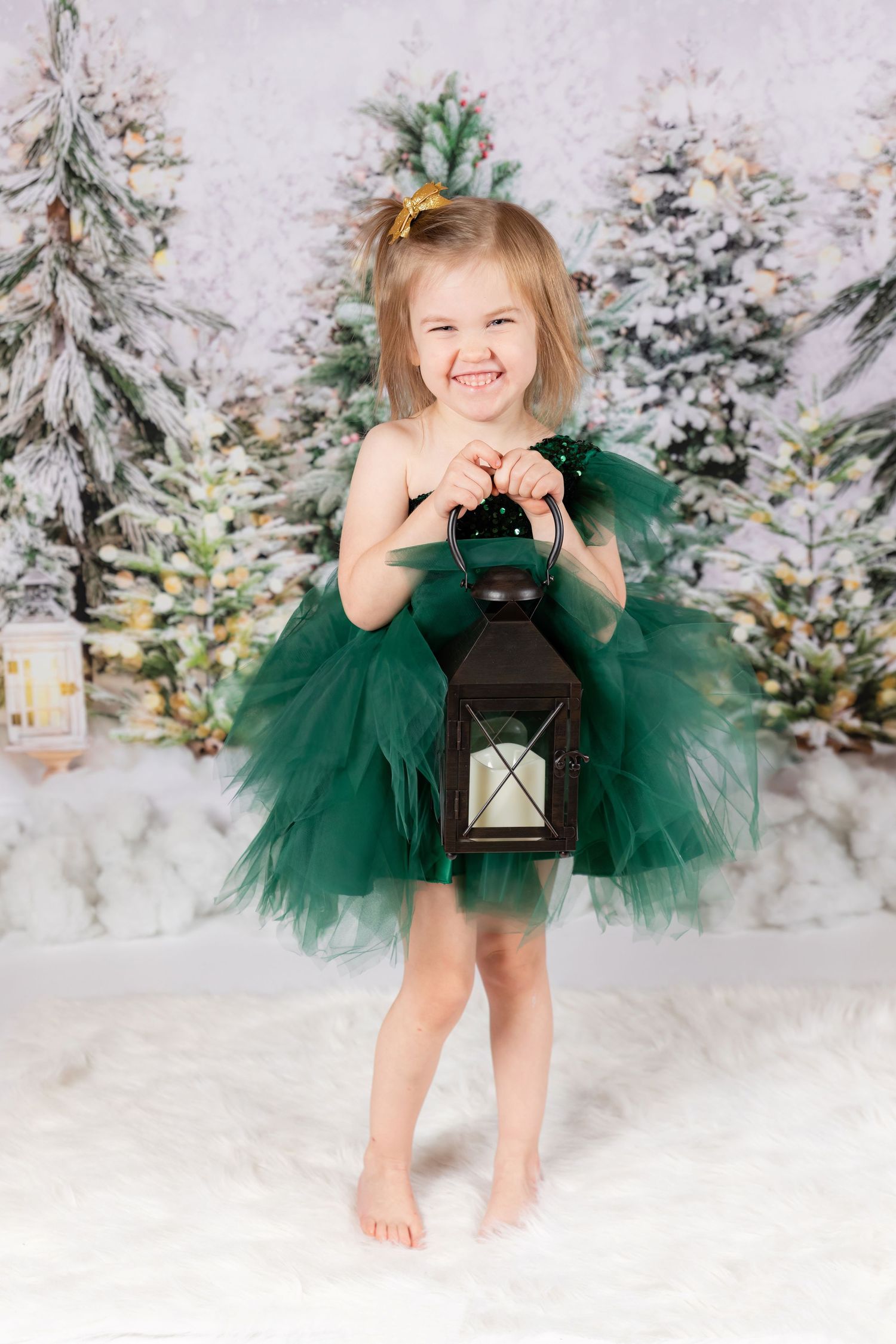 girl child in green dress holding lantern smiling on christmas tree backdrop in studio clayton new jersey Gloucester