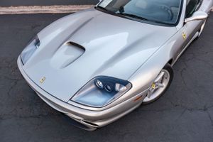 Close-up view of a silver Ferrari's front end showing sleek headlights and hood scoop design.