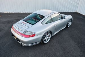 Rear three-quarter view of a silver Porsche 911 showcasing its iconic sloping roofline.