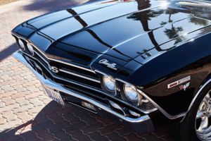 Front grille and headlight detail of a classic black Chevelle muscle car.