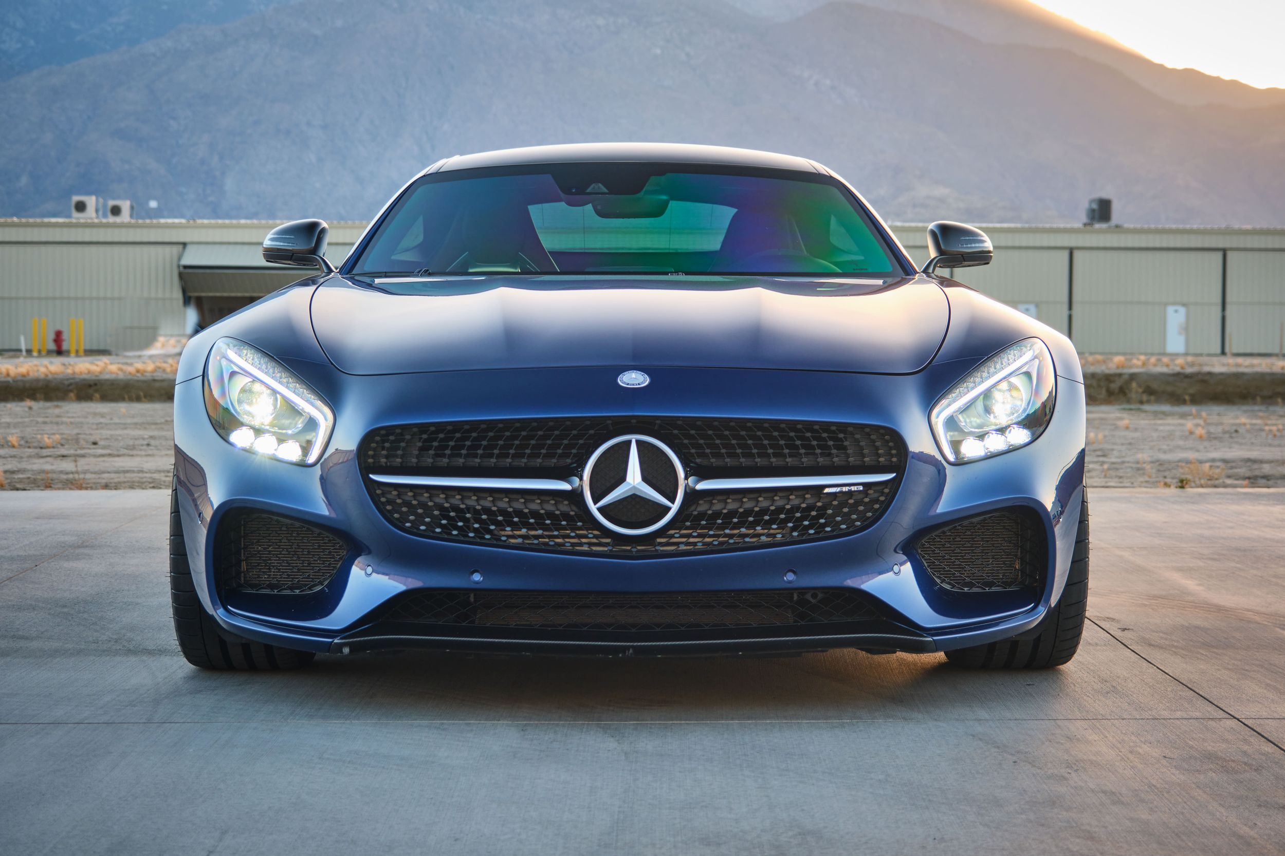 Front view of Mercedes AMG GT sports car with striking LED headlights.