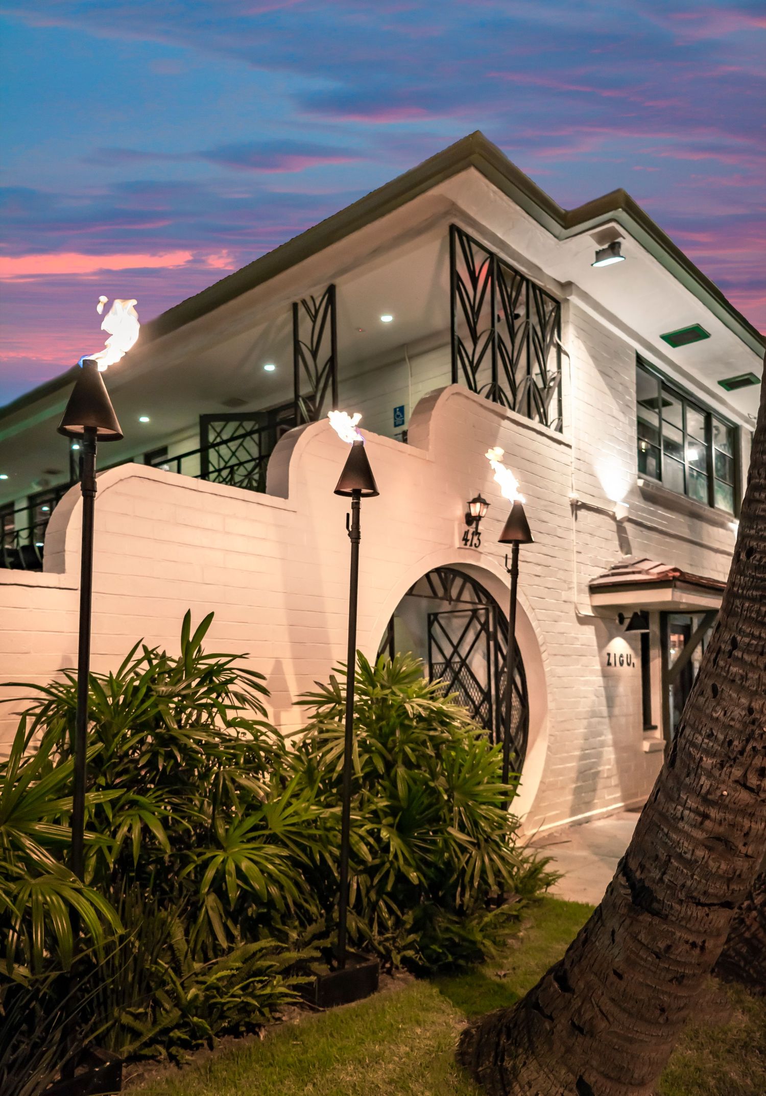 Modern white house with architectural details illuminated at sunset with pink sky. Realestate Photography