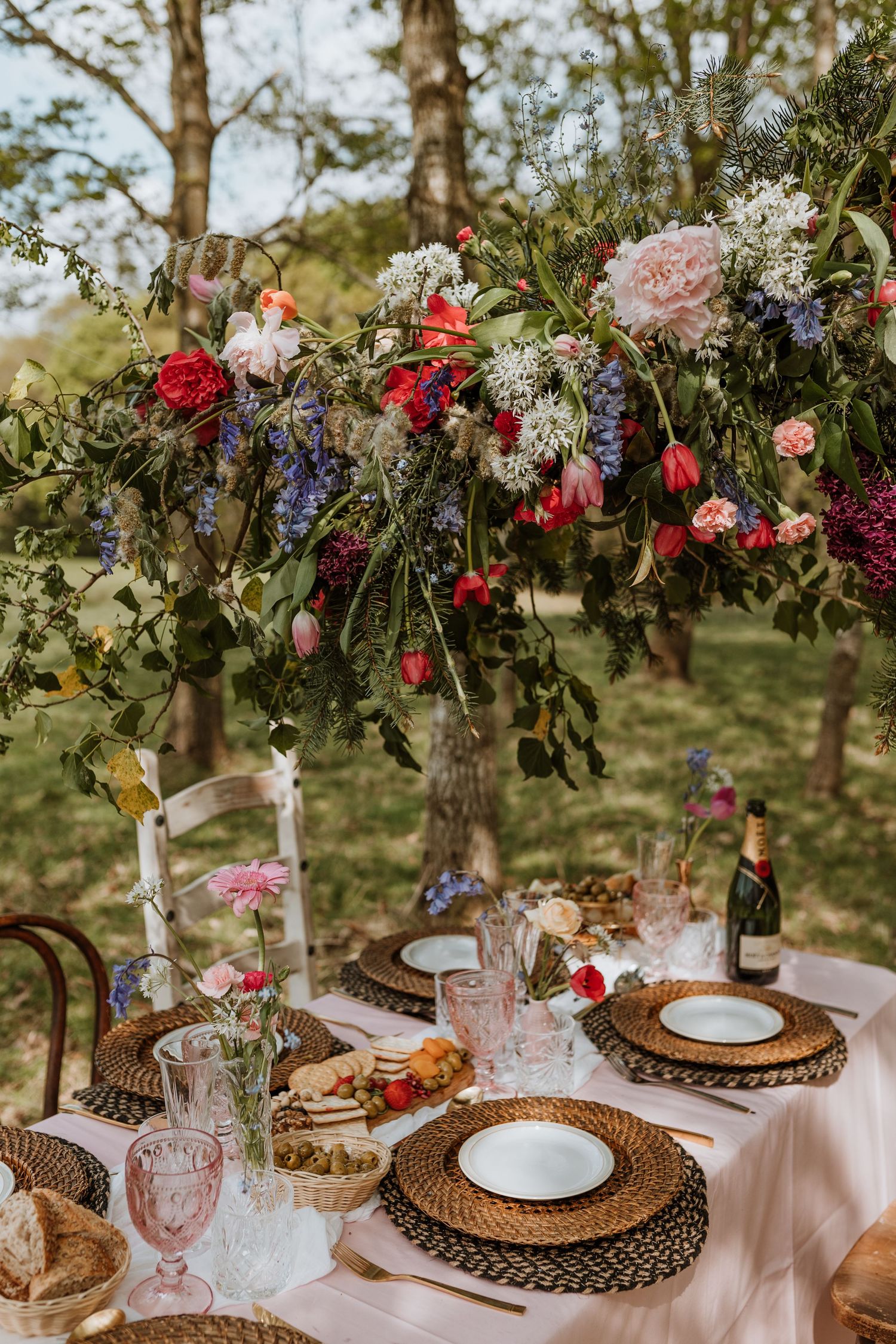 Gorgeous outdoor set up in Welsh countryside for wedding breakfast using spring florals and colours