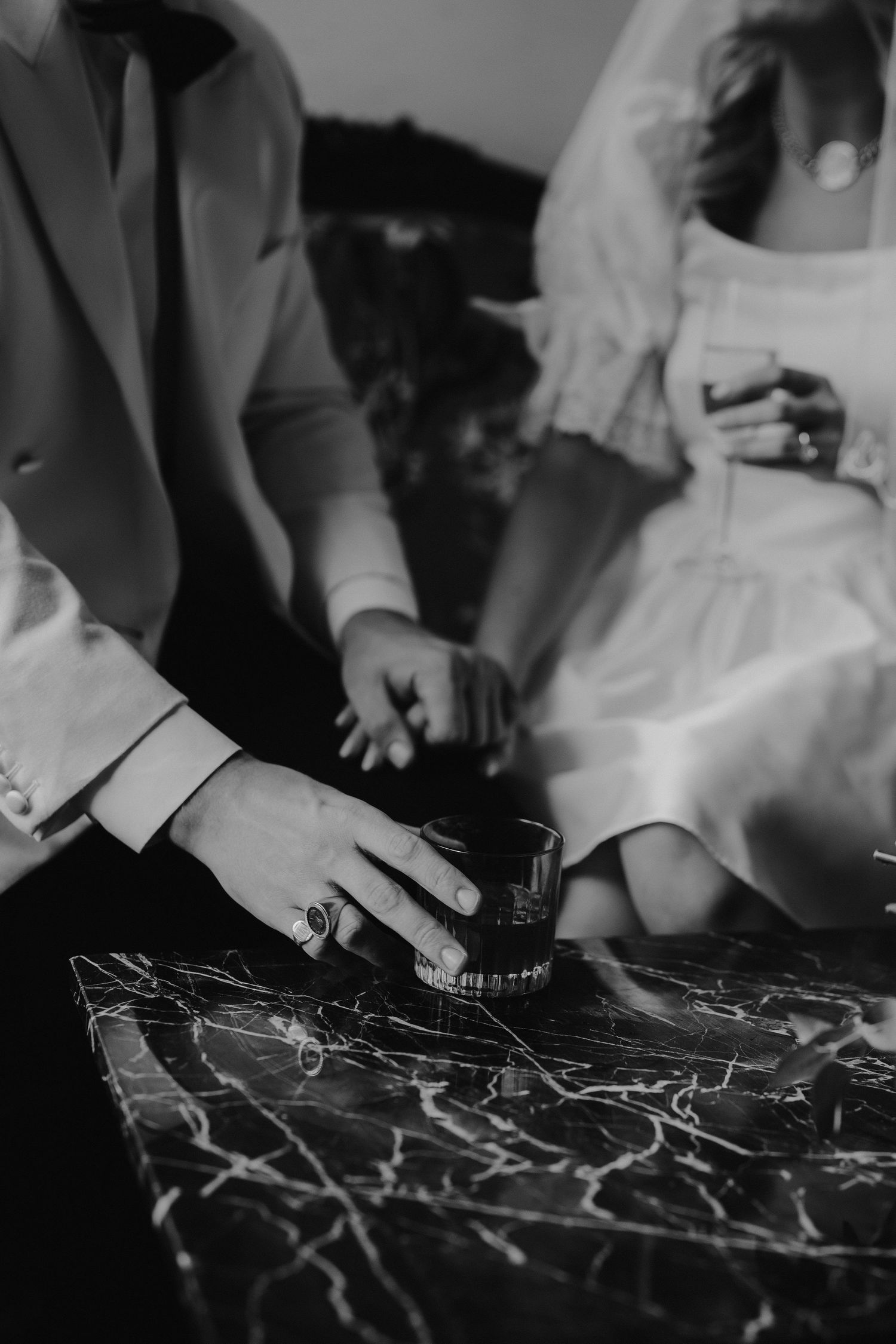 grooms hand holding whiskey glass at the Randolph hotel in oxford