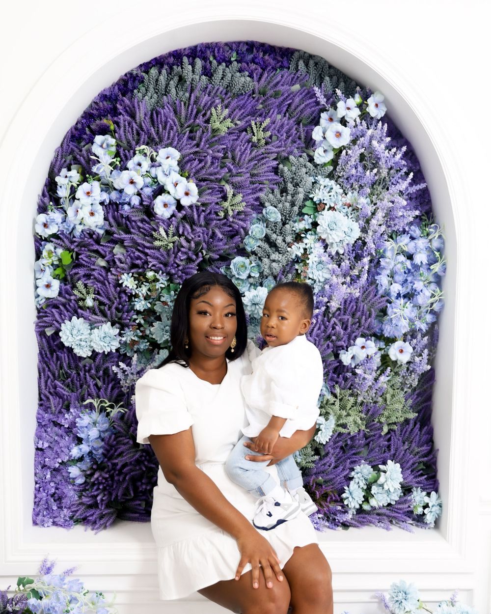 Stunning floral arch backdrop with purple and white flowers creating an elegant setting.
