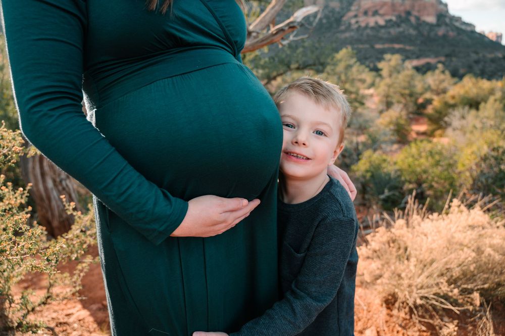 A family shares tender moments together on red desert terrain with mountain views.