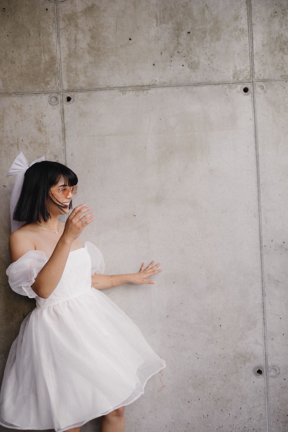 Dynamic dance movements captured against an industrial concrete wall background.
