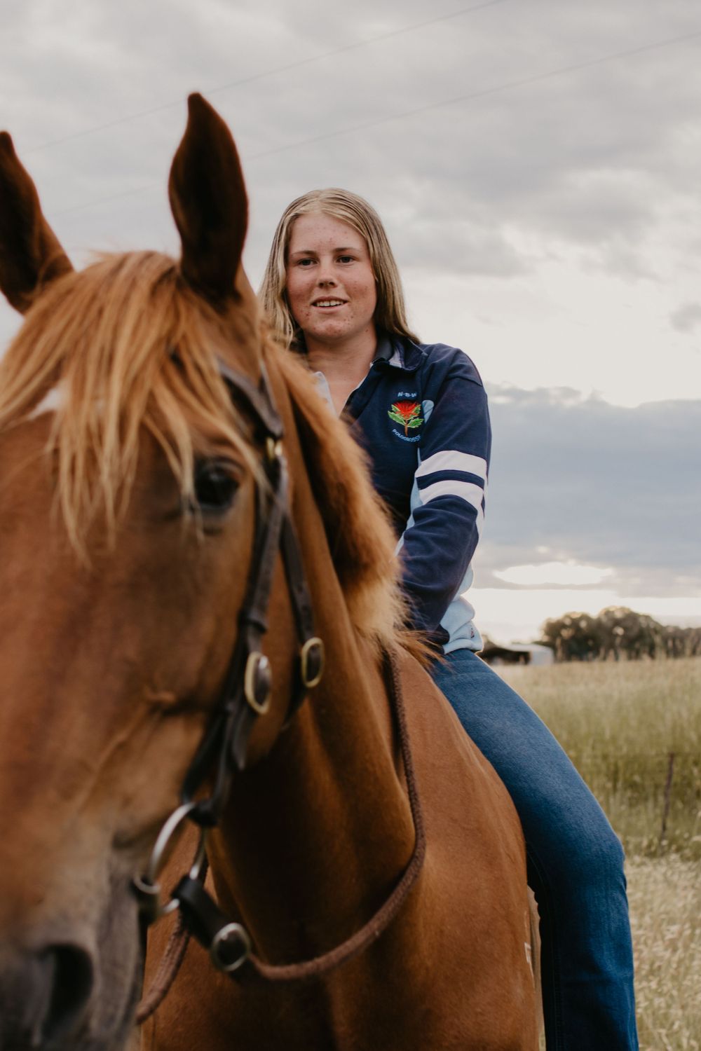 Girl sitting on her horse in a rural landscape