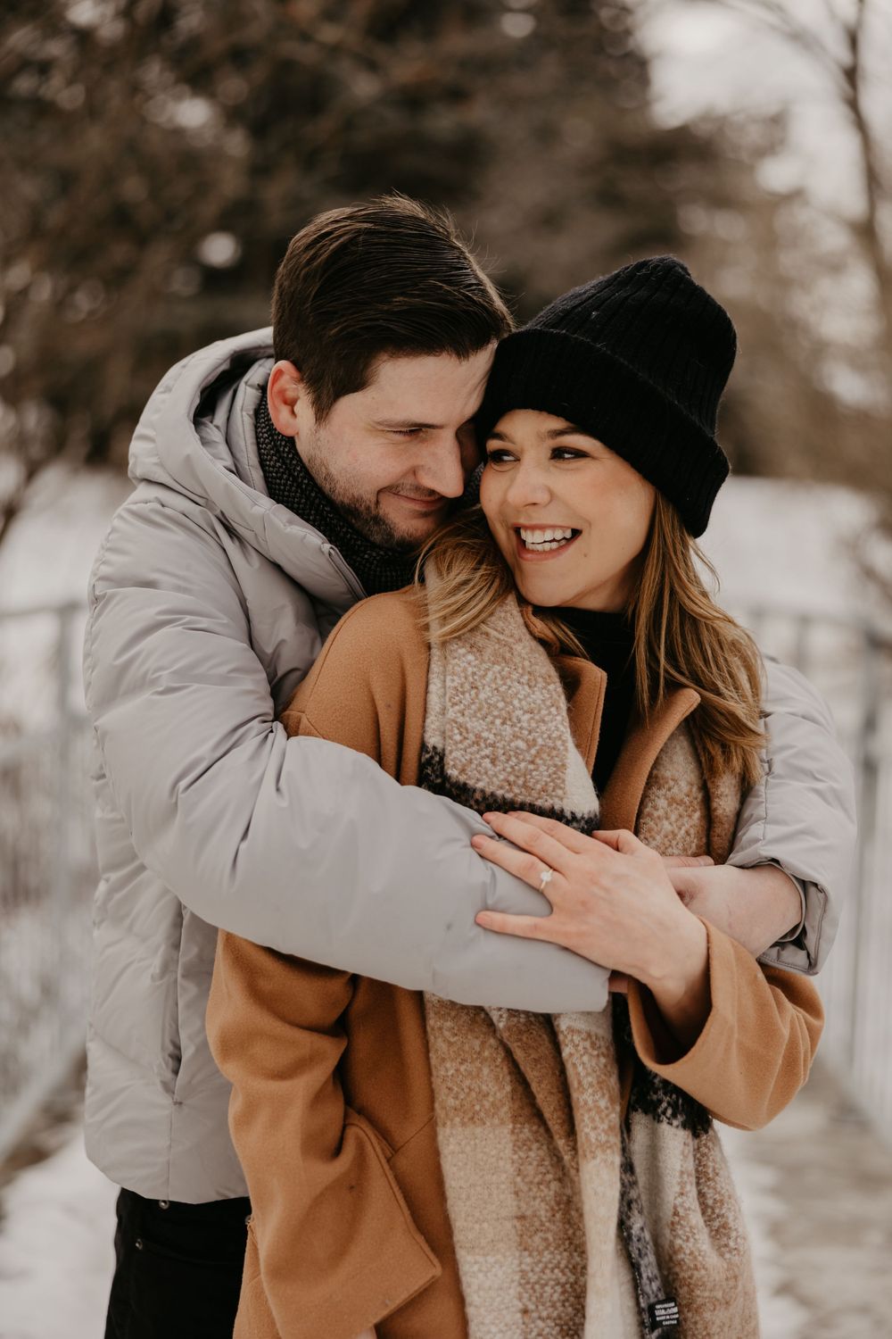 Cozy winter engagement photos showing affectionate couple in warm winter attire.