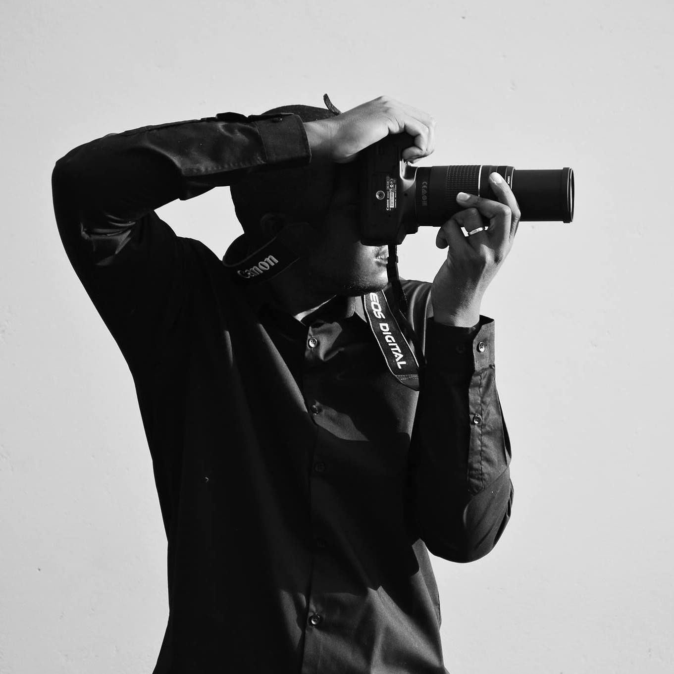 Photographer in black outfit with a camera