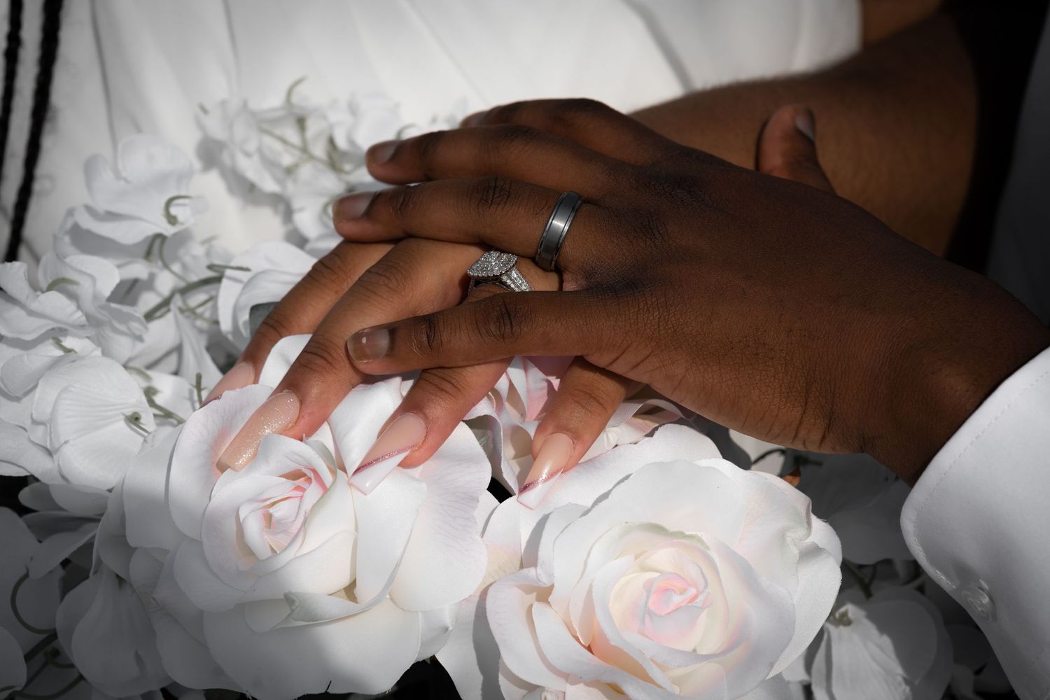 Close-up of hands holding delicate white rose flowers.