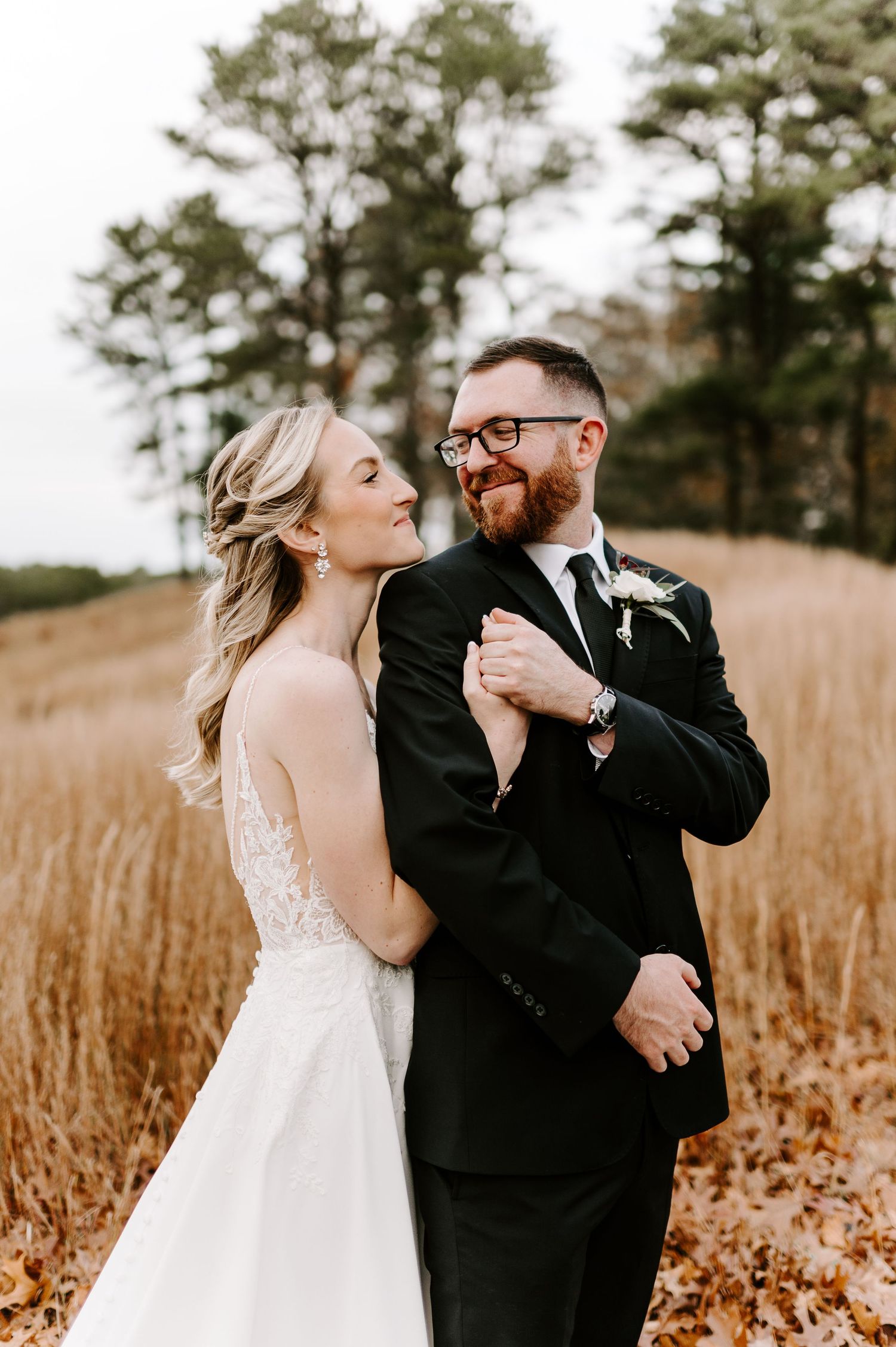 Candid moments of joy between newlyweds in a serene autumn field setting.