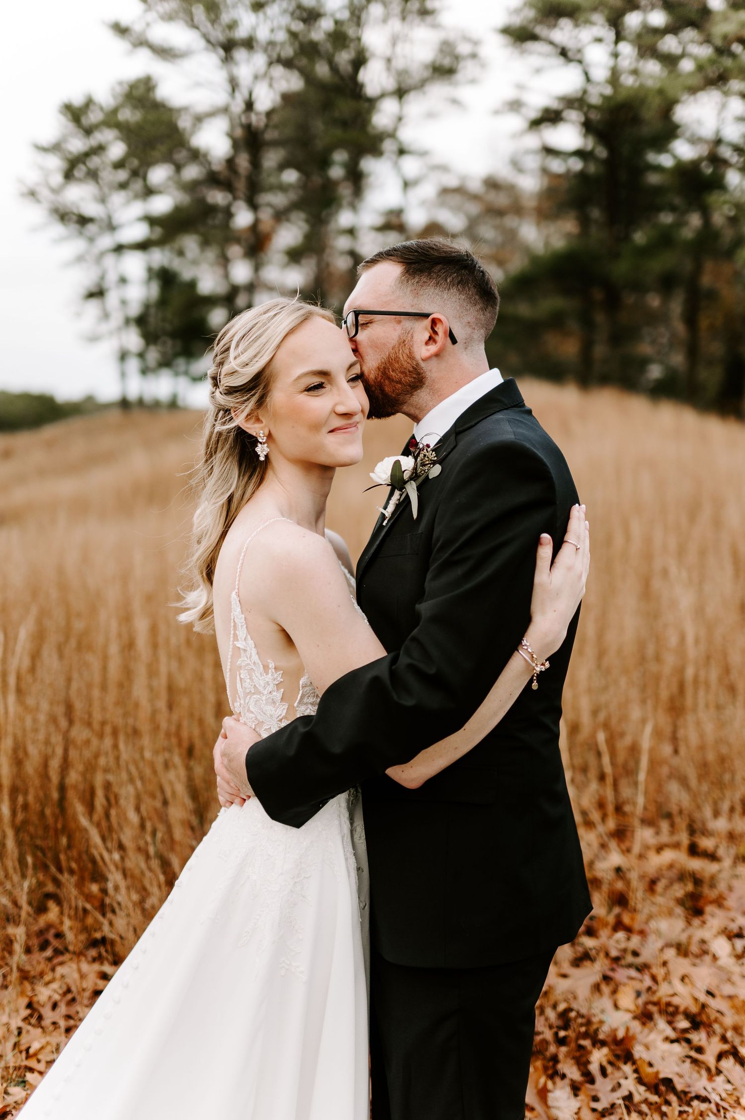 Tender wedding portraits taken in a golden field during fall season.