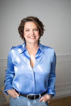 Confident professional in blue satin blouse poses for modern branding portrait in London