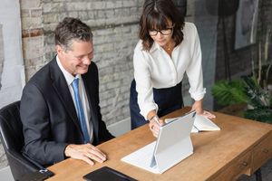 Branding photography of two business professionals collaborating at a desk, capturing leadership, teamwork, and corporate success.