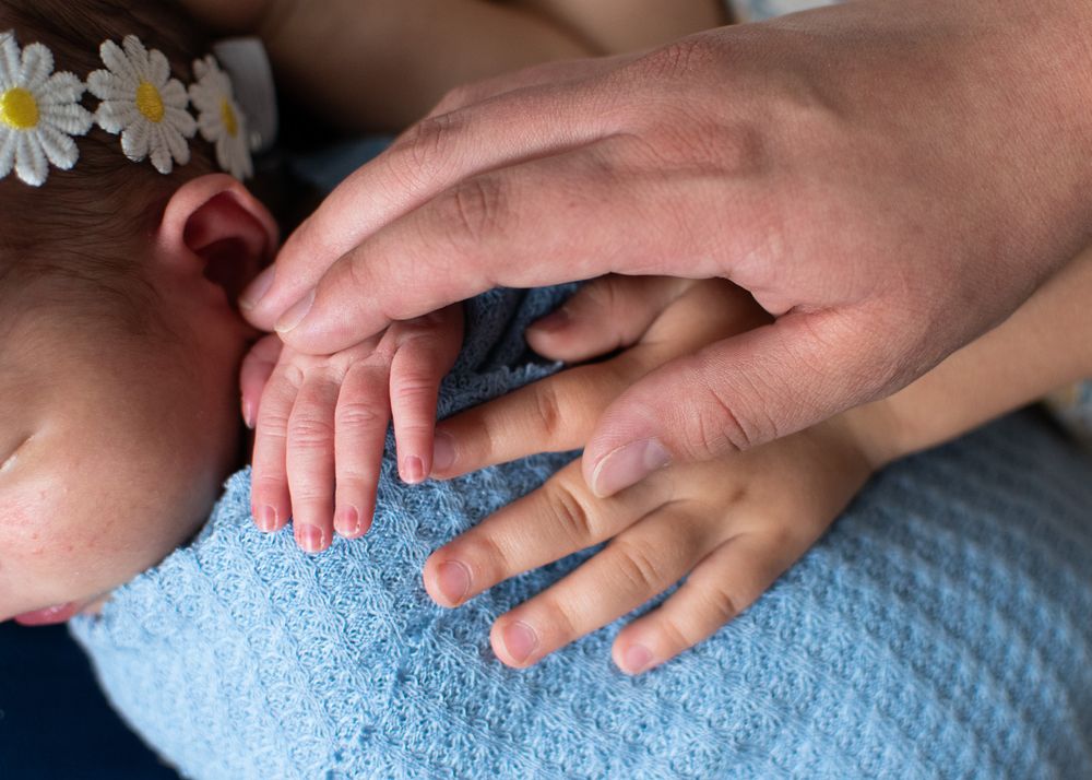 mom, older sister, and baby's hands