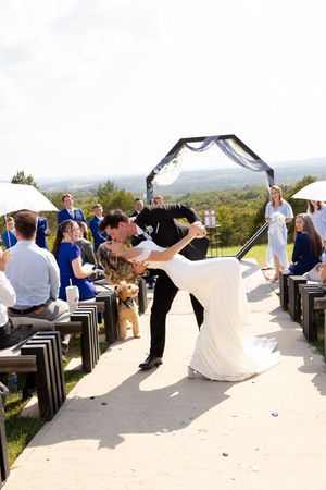 A panoramic sequence of a wedding party celebrating on an outdoor terrace with scenic mountain views in the background.
