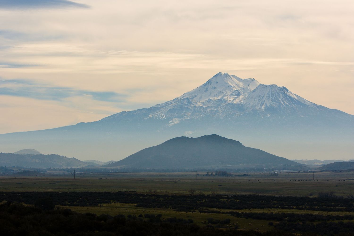 A misty view of Mt Shasta with Black Butte in front.