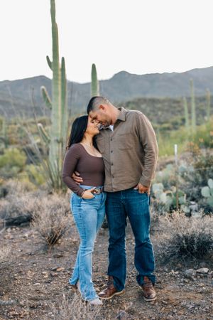 Romantic Tucson couples portrait of a couple kissing in the desert with saguaros and soft sunset light.
