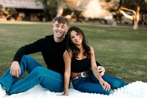 Natural Tucson couples portrait of a young couple sitting together on the grass in a park at sunset.
