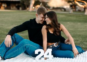 Tucson couple photo sitting on a blanket in a park, celebrating their relationship with number 24 decor.