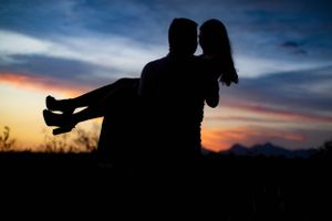 Tucson couples silhouette photo of a man and woman embracing at sunset with vibrant desert skies.