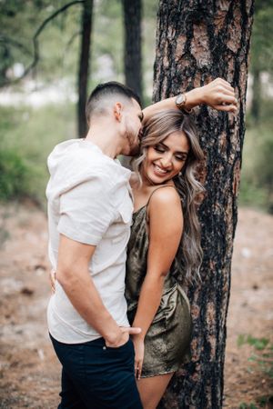 Tucson couples photo of a man and woman hugging in a wooded area with natural, earthy tones in Mt. Lemmon.
