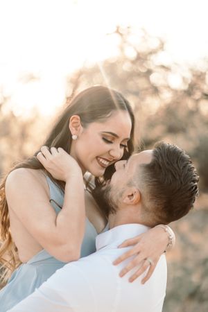 Soft golden-hour Tucson wedding photo of a groom kissing his bride’s forehead in the desert.