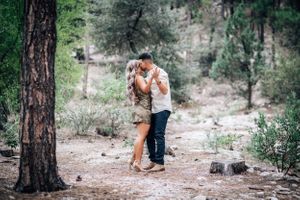 Tucson couples portrait of a couple hugging in a Mt. Lemmon setting with tall pine trees and soft natural light.