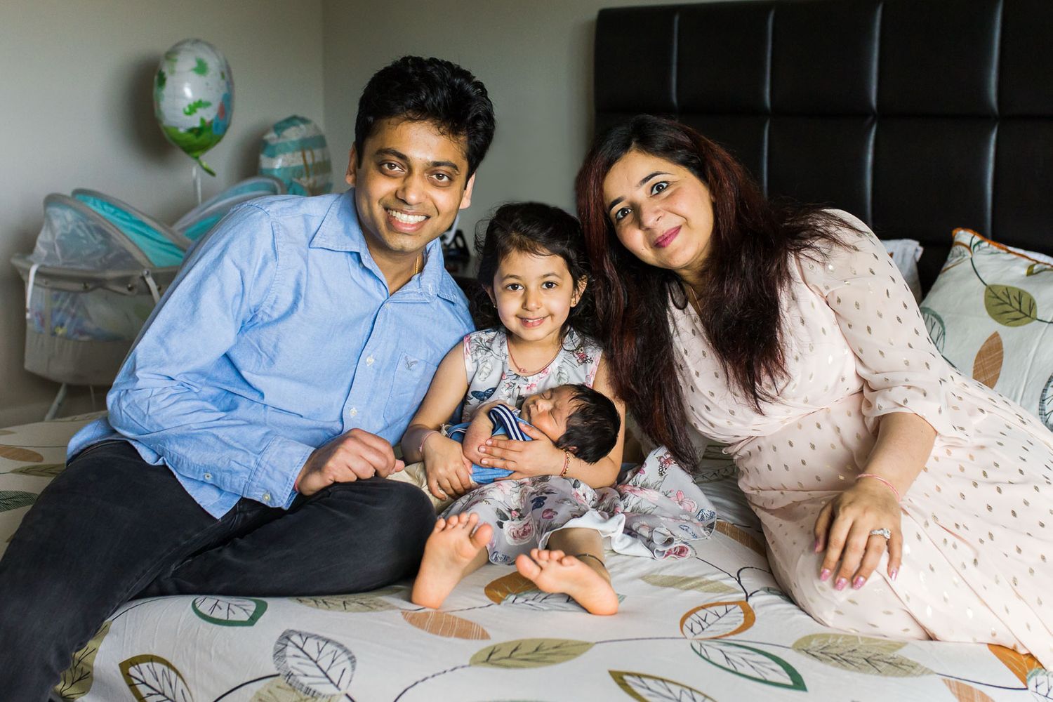 Family poses for a portrait on their bed