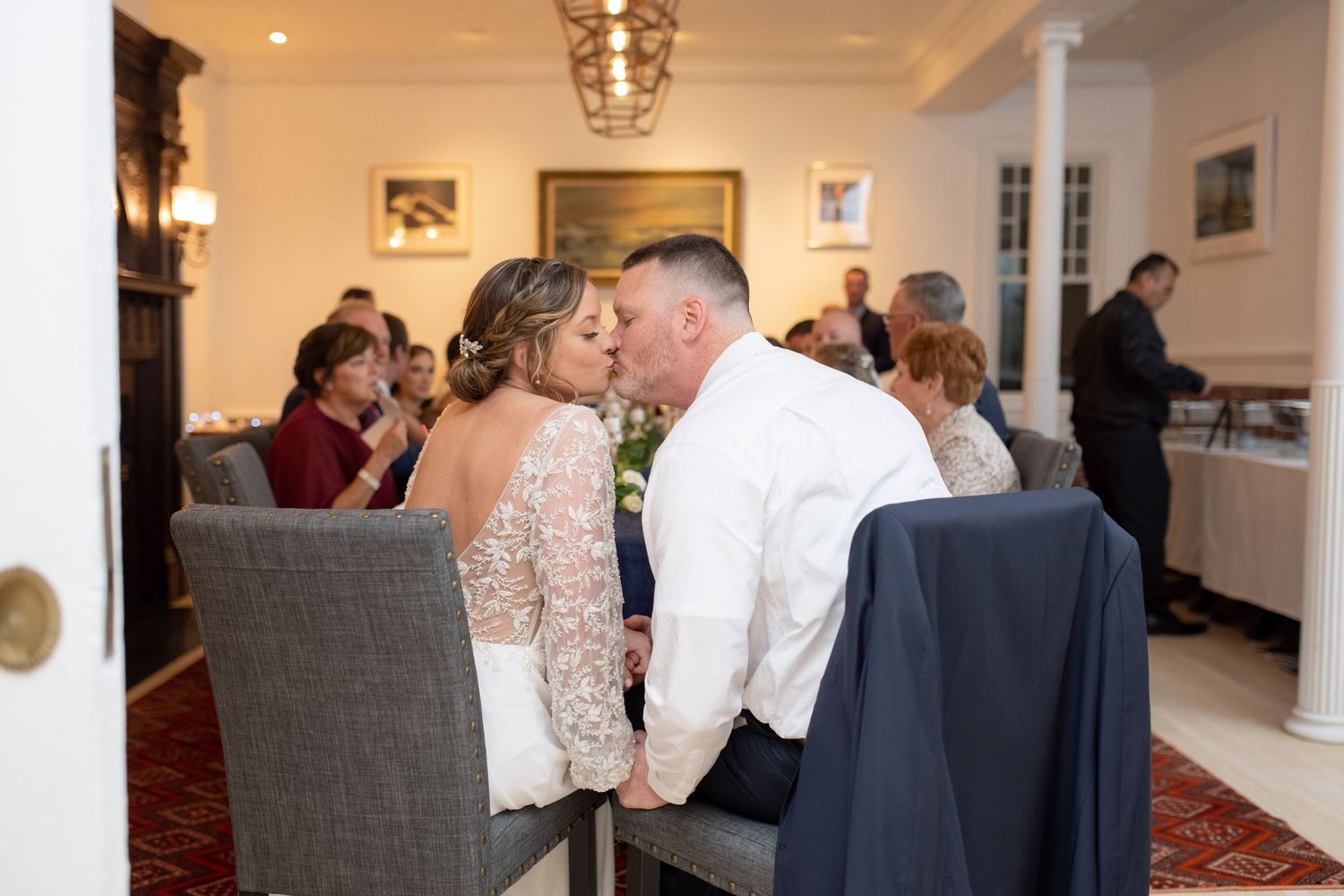 Elegant indoor wedding reception with chandeliers and formal dining setup.