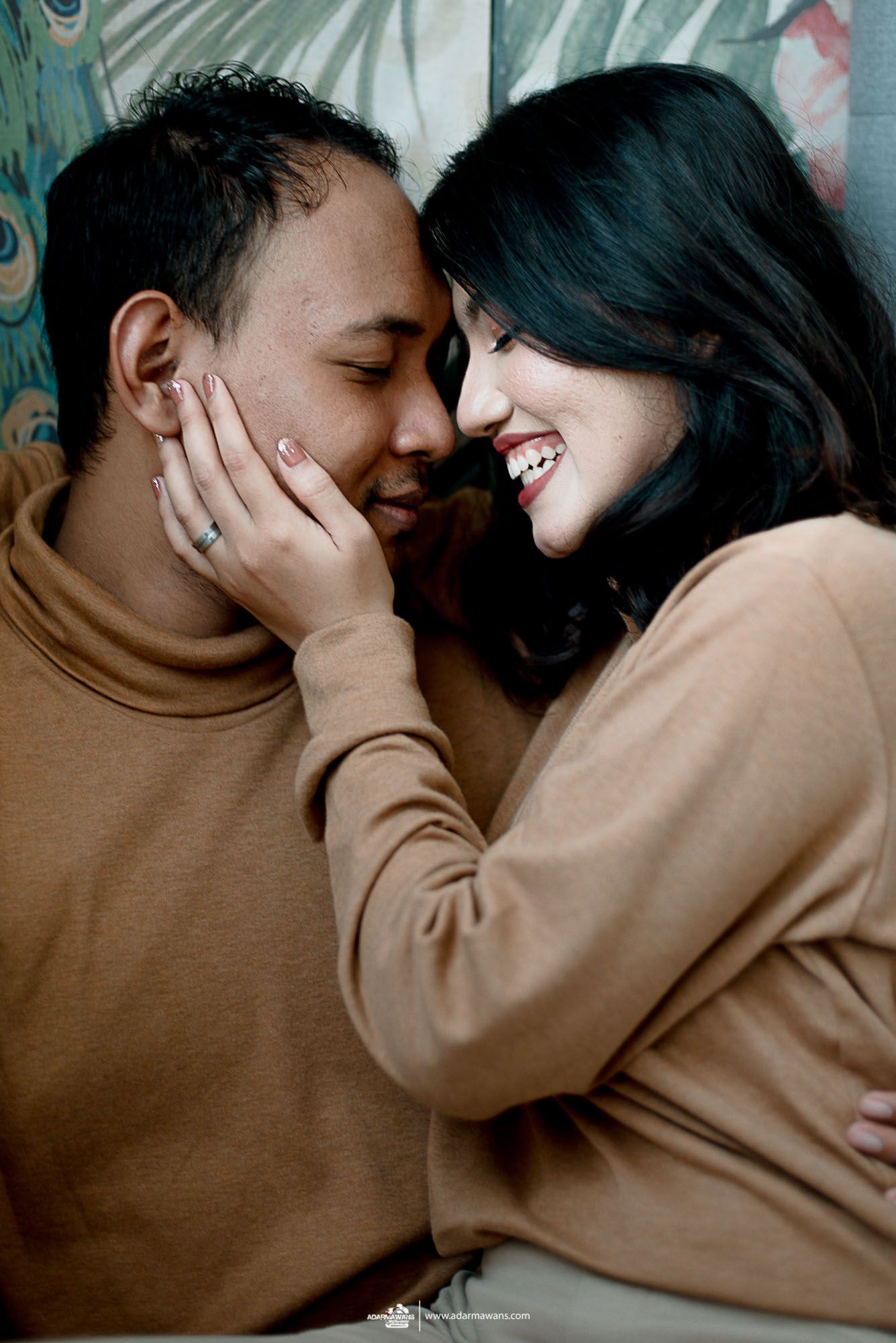 Intimate close-up of couple in matching beige sweaters sharing tender moment.