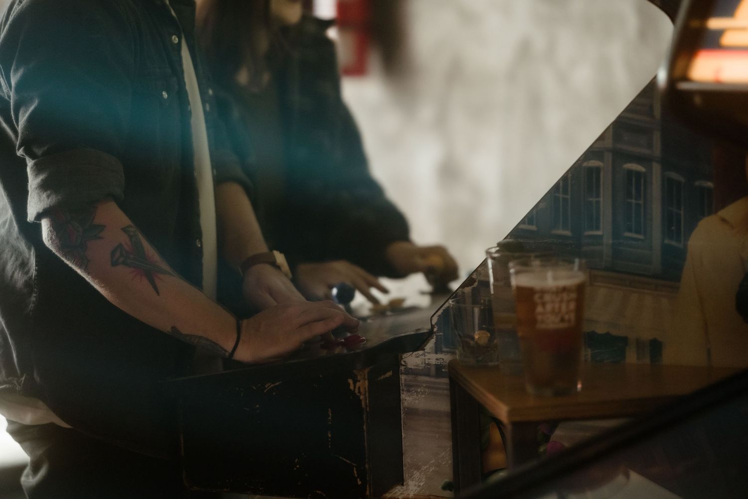 Close-up shot of hands preparing drinks at a bar with soft ambient lighting.