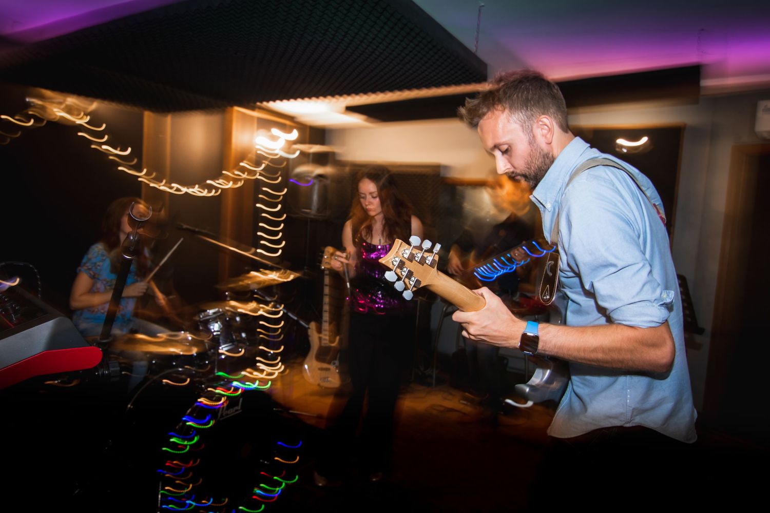 man playing guitar with band behind