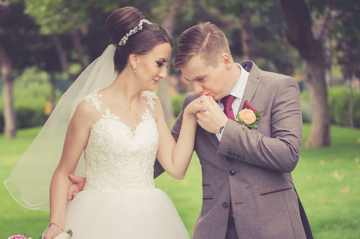 Romantic wedding moment with couple in formal attire in garden setting.