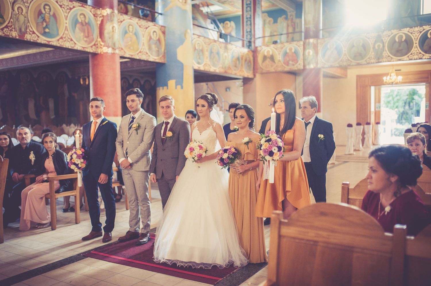 Traditional church wedding ceremony with wedding party in formal attire and yellow bridesmaid dresses.