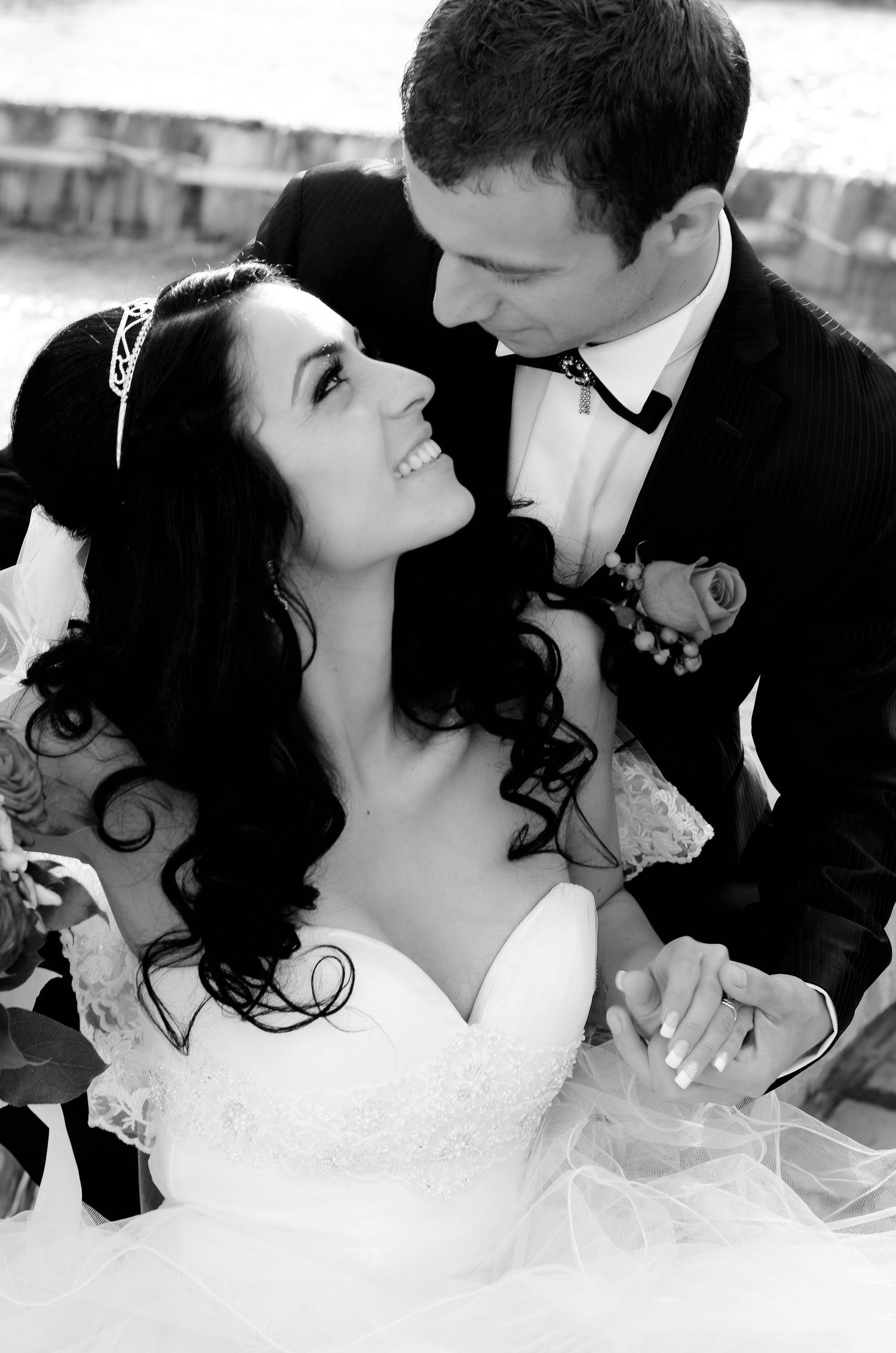 Black and white romantic portrait of newlyweds in formal wedding attire.
