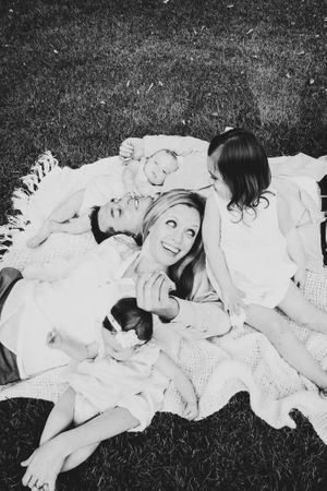 Candid black and white photos of people laying on grass sharing joyful moments.