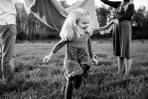 Black and white images of children playing in a grassy field on a sunny day.