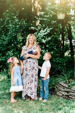Family gathering outdoors in a garden setting with blooming greenery and natural sunlight.