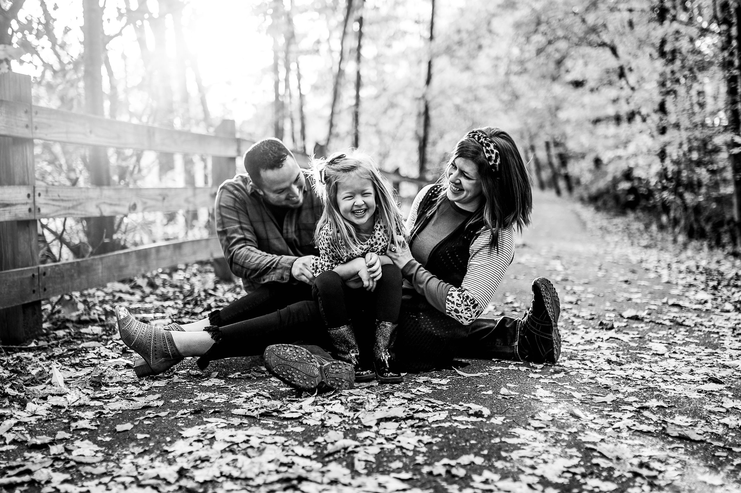 Black and white family photos taken in autumn leaves.