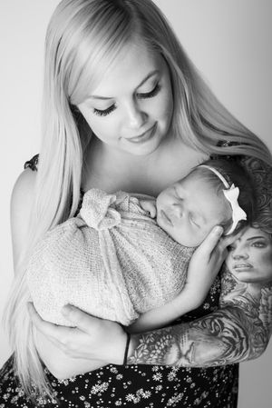 Intimate black and white portraits showing gentle maternal moments with soft lighting and tender expressions.