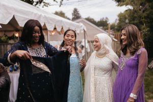 Wedding guests in colorful formal attire celebrating together outdoors.