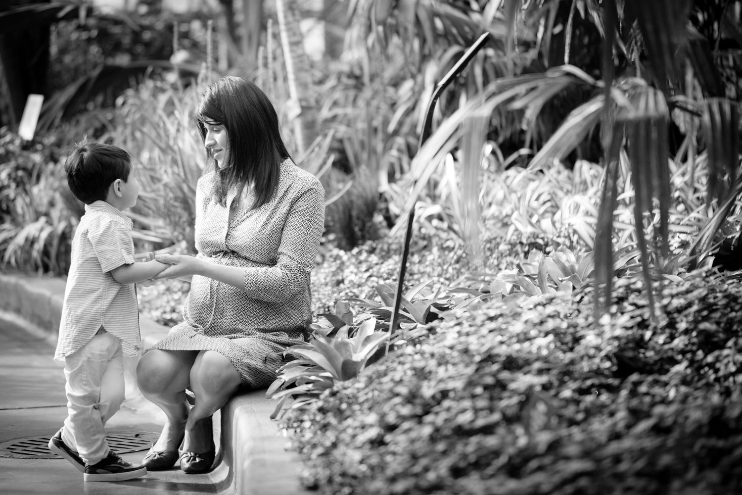 Black and white family portraits captured in a garden setting with natural light.