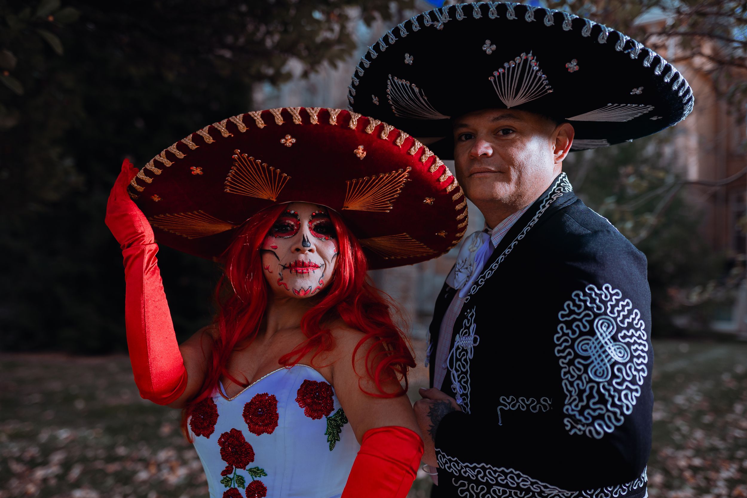 Day of the Dead themed couple in traditional Mexican formal wear with sugar skull makeup.